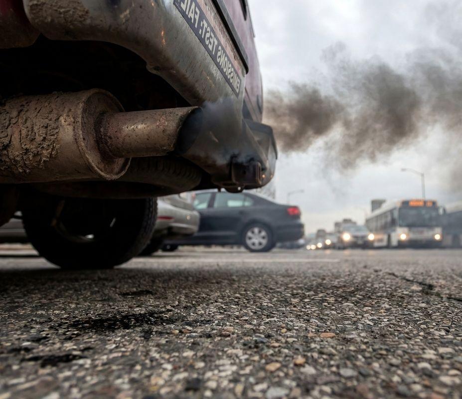 Exhaust pipe releasing thick gray smoke.