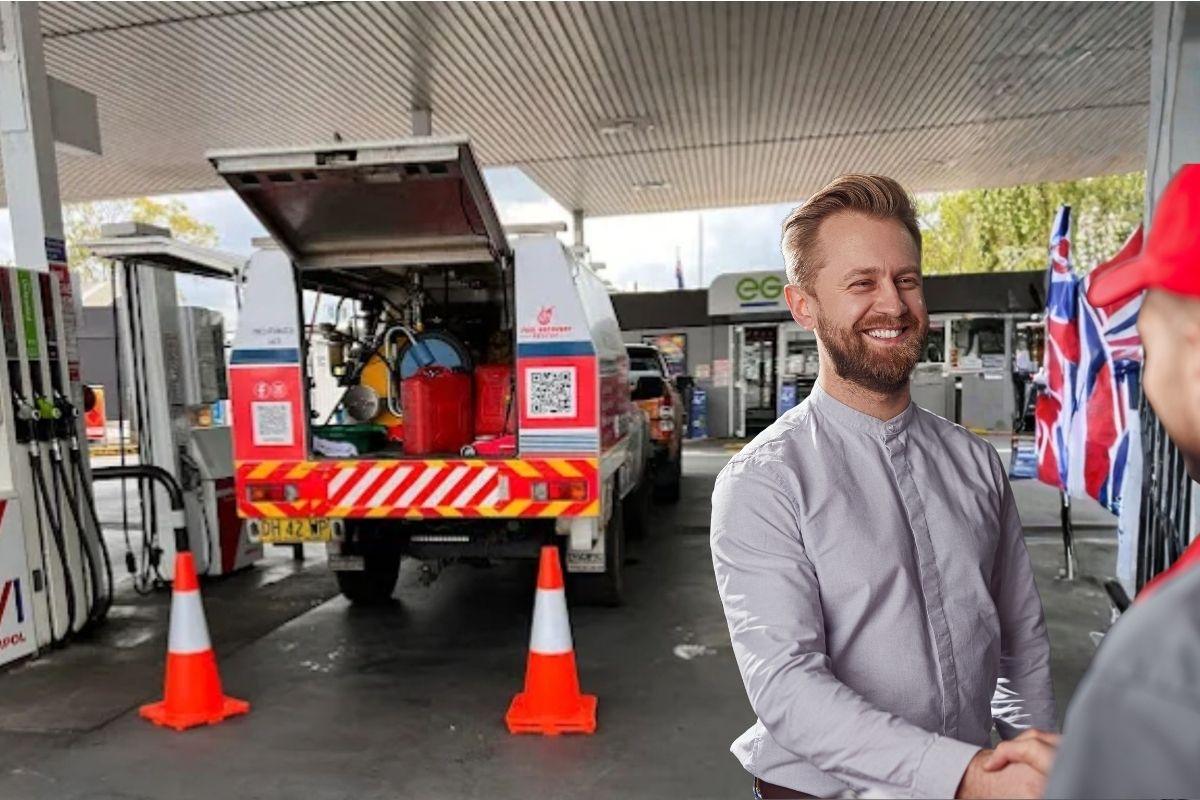 A man looking happy at a gas station. 